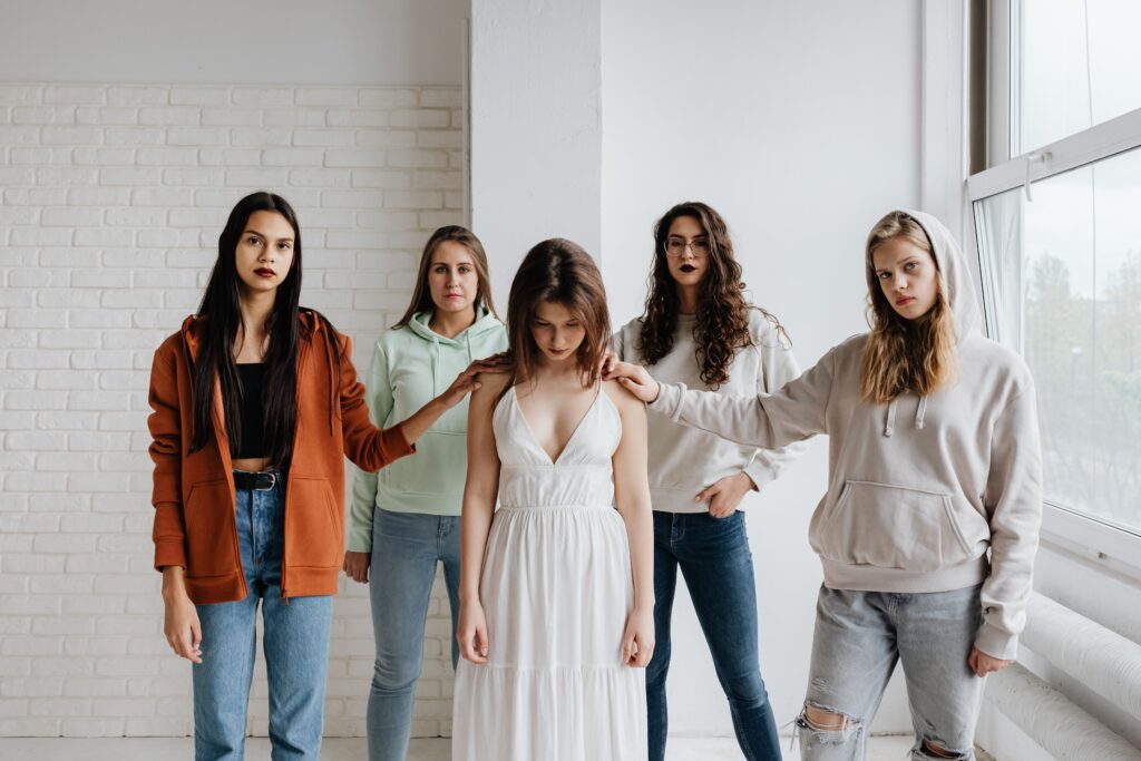 pexels-photo-8107446-8107446 Frauen stehen im Kreis und unterstützen eine Frau mit gesenktem Kopf in der Mitte als sicherer Raum zur Bewältigung von Kindheitstraumata